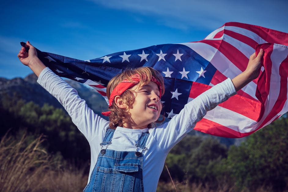 criança correndo segurando nas mãos bandeira dos estados unidos