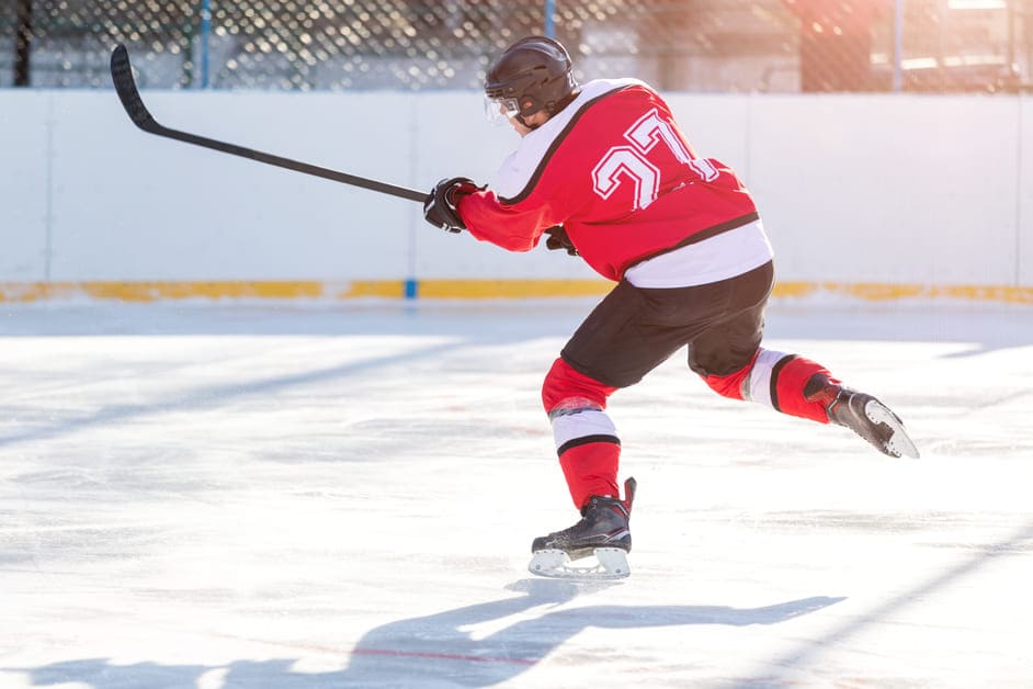 Homem jogando hóquei com uniforme do Canadá
