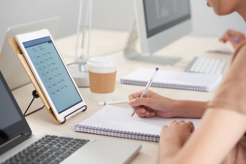 menina com tablet e carderno estudando inglês online
