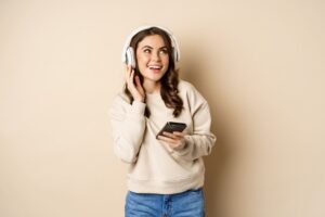 mulher com fone de ouvido e celular na mão