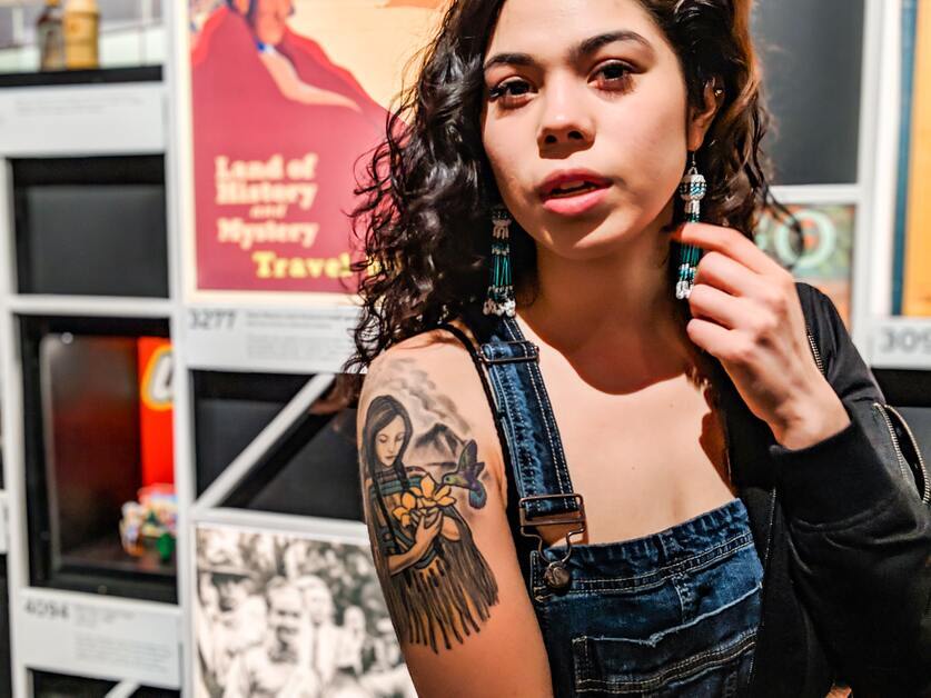 mulher jovem e morena com tatuagem no braço direito