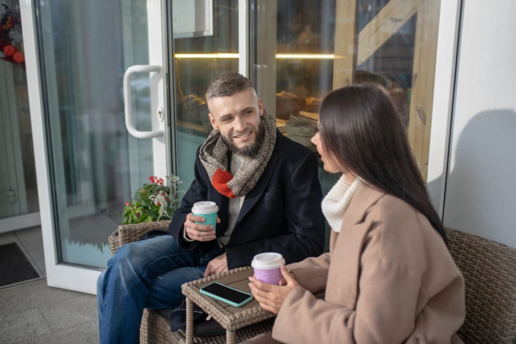 homem e mulher jovens sentados conversando um com o outro