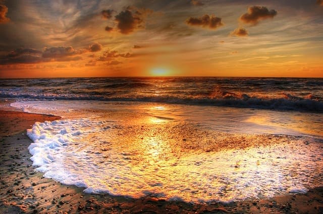 ondas em praia na Austrália em pôr do sol laranja