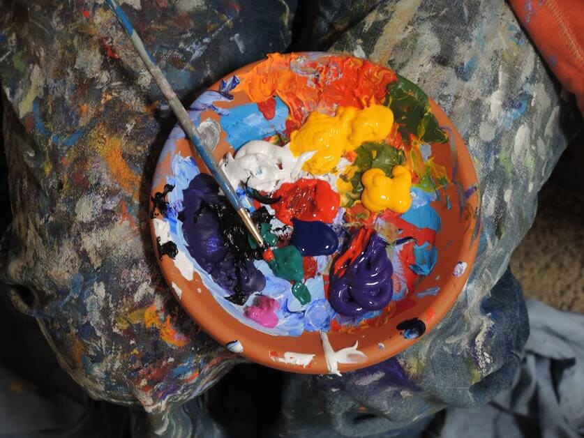 Tintas coloridas misturadas em pote laranja