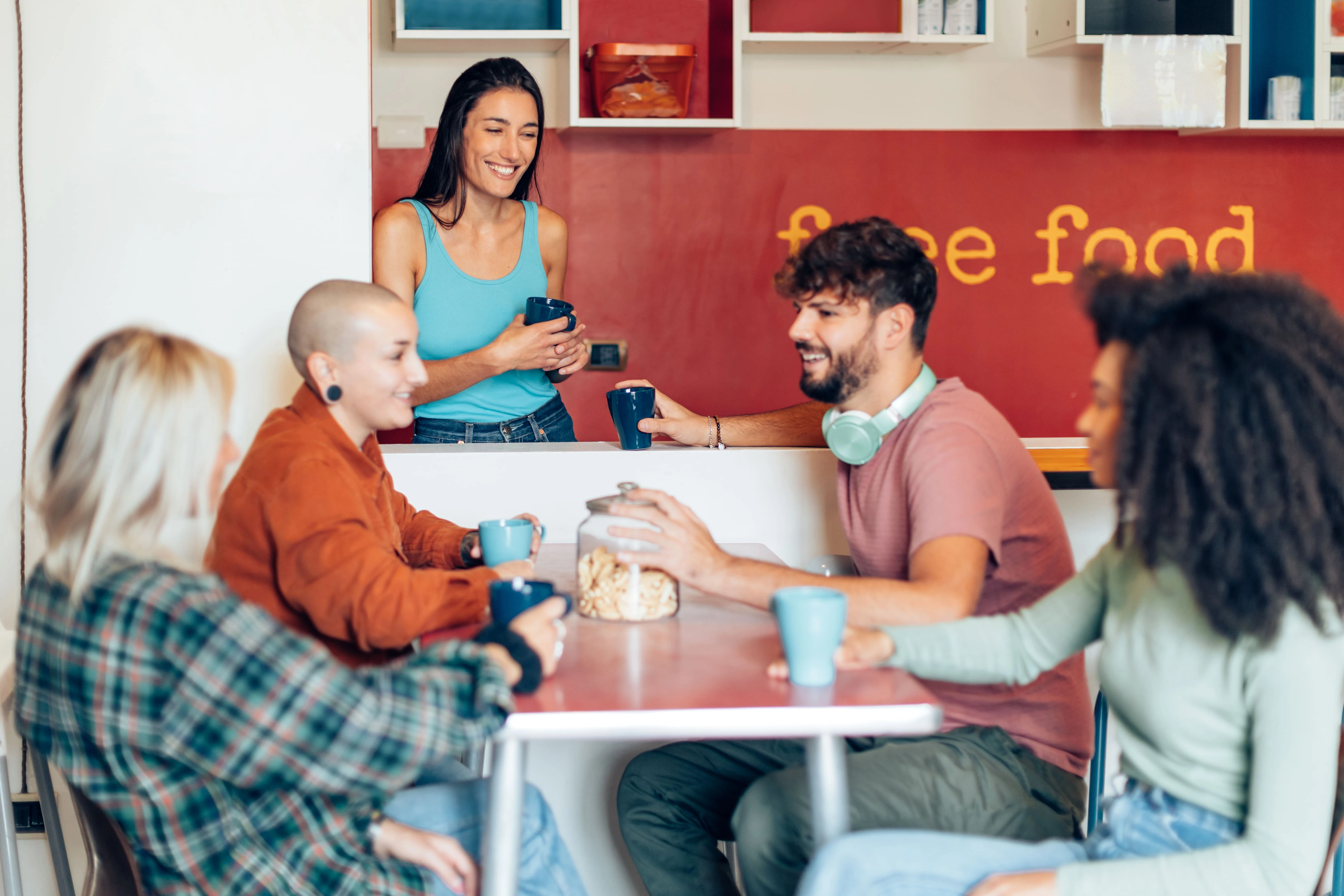Estudantes conversando e tomando café em uma residência estudantil