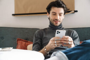 homem usando fones de ouvido mexendo no celular