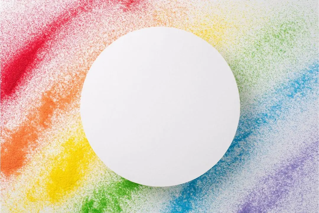 Círculo branco centralizado sobre fundo com respingos coloridos, representando a cor branca entre as demais cores em inglês