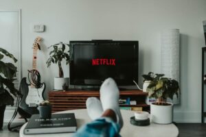 pé na mesa na frente da TV com netflix na tela