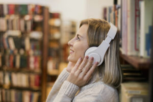 mulher com fone de ouvido na biblioteca