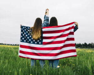 meninas com bandeira dos estados unidos apontando para avião