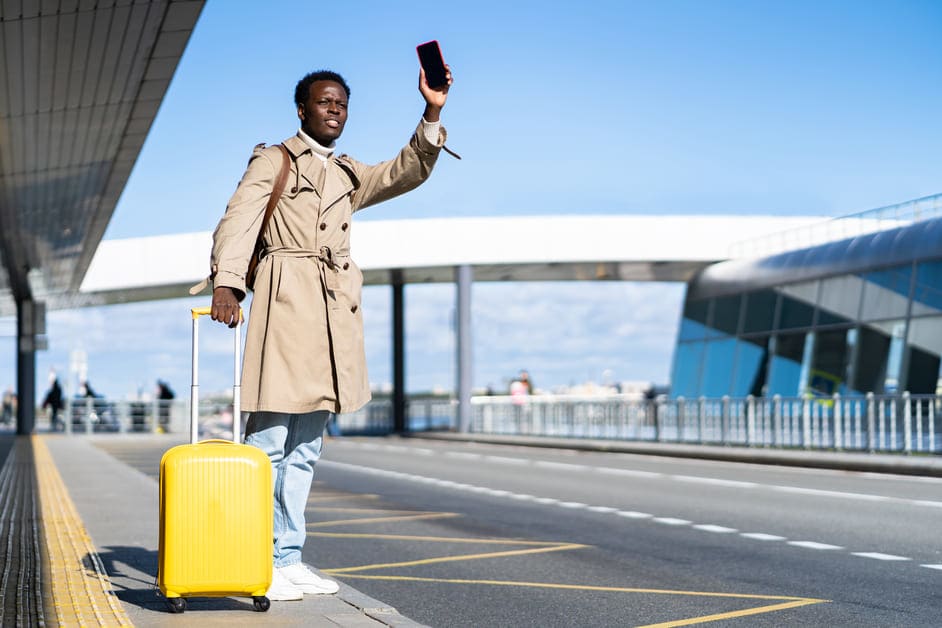 homem com mochila amarela no aeroporto dando sinal para taxi