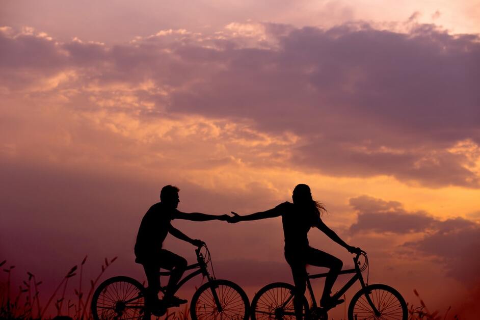 sombra de casal andando de bicicleta no pôr do sol