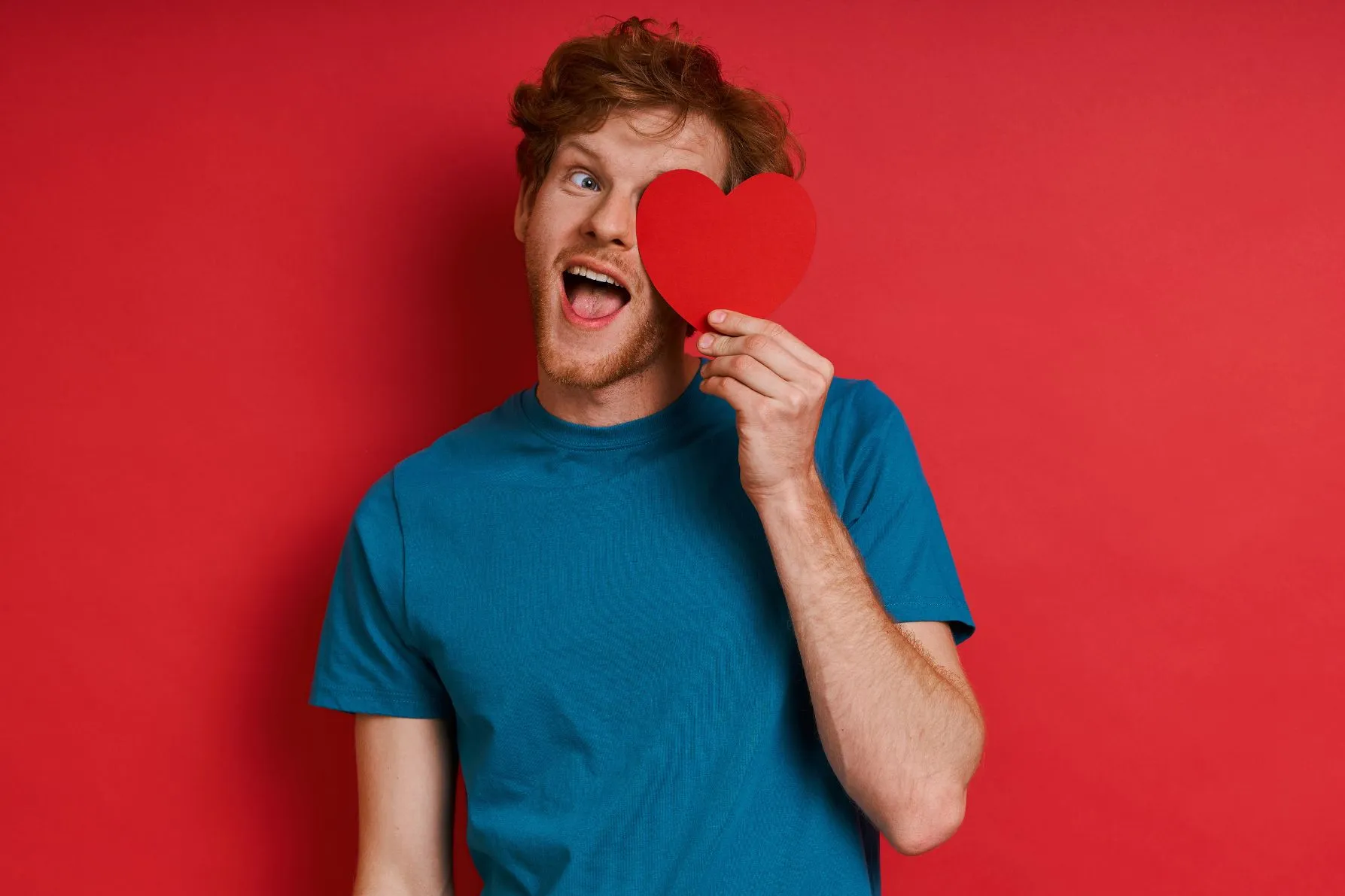 Homem segurando um coração na frente do rosto