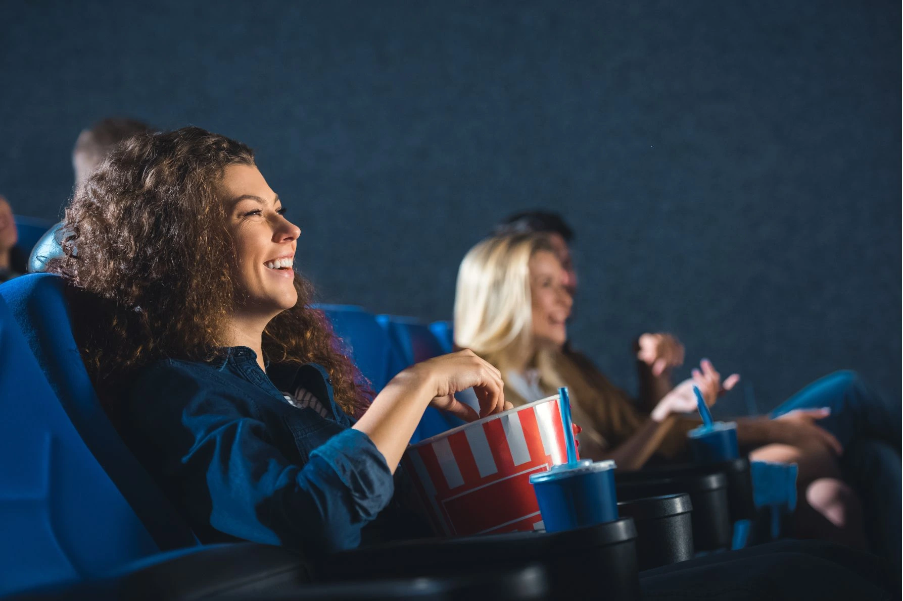 Mulher em um cinema comendo pipoca