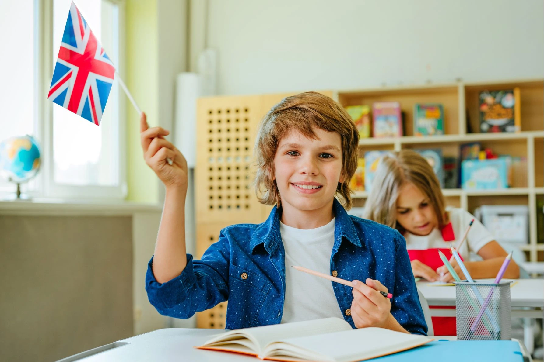 Criança em sala de aula segurando bandeira
