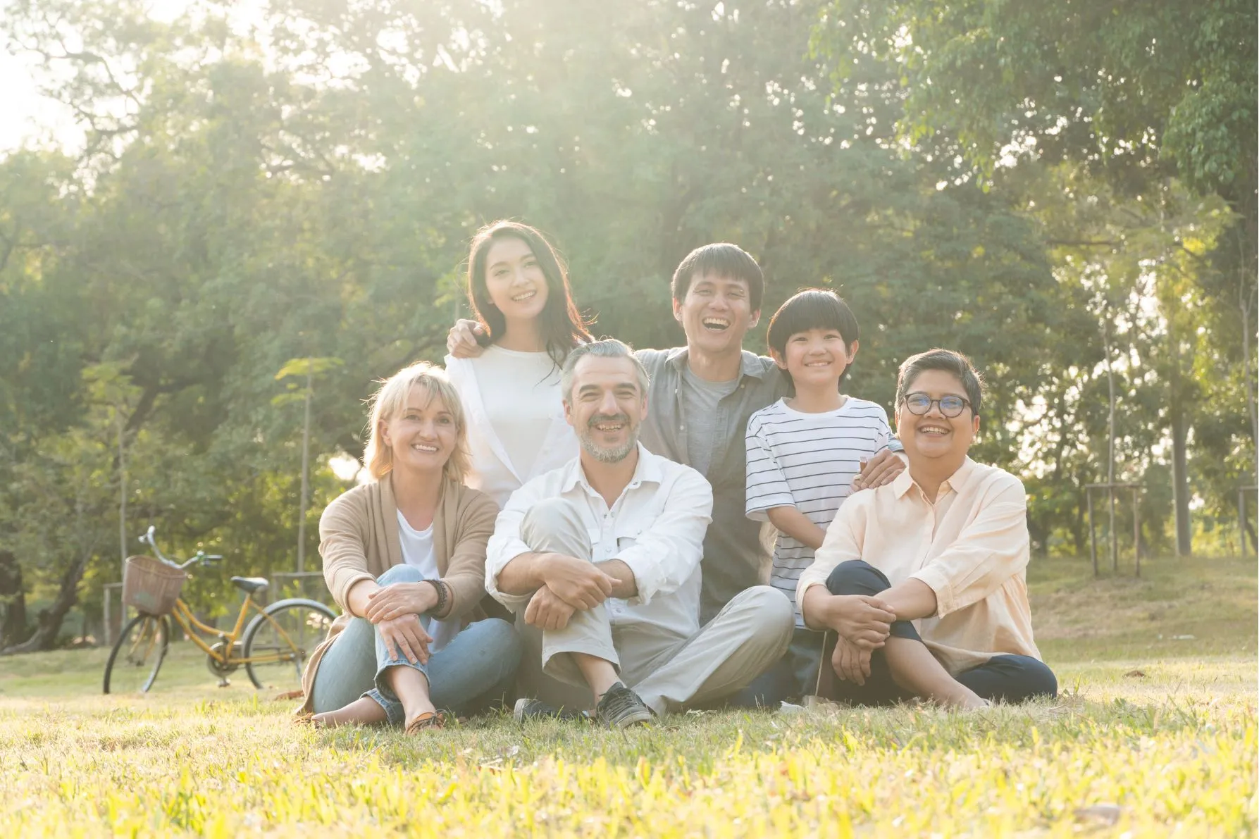 Família sentadas na grama em um dia ensolarado