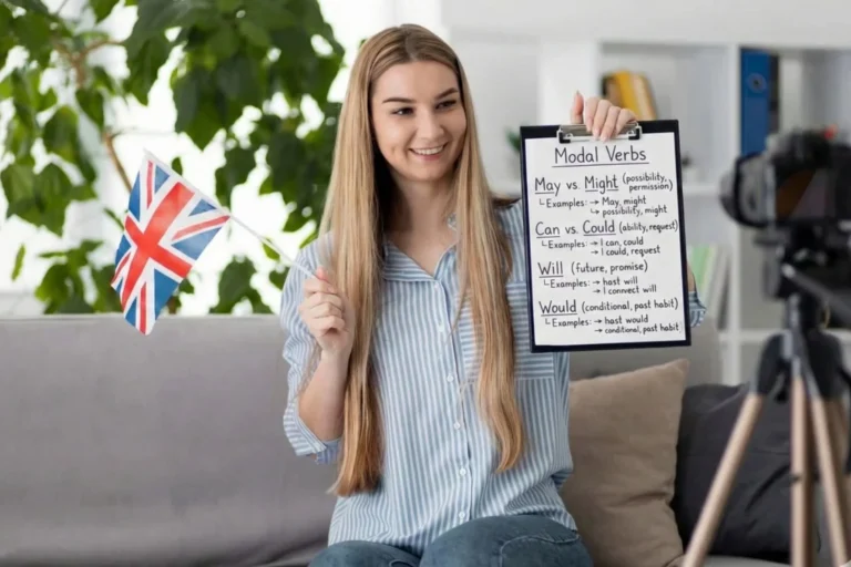Professora de inglês segurando uma lousa e uma bandeira